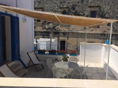 a patio with a table and chairs on a balcony at Janela Blue in Otranto