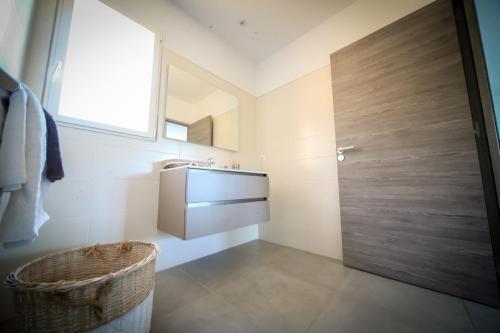 a bathroom with a sink and a wooden door at SARL Valinco locations appartement 2 chambres in Olmeto