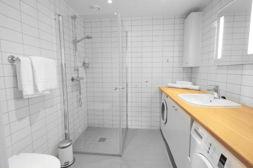 a bathroom with a shower and a toilet and a sink at Wright Apartments - Sørenga in Oslo