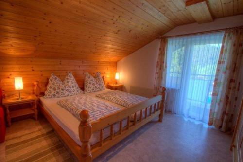 a bedroom with a bed in a wooden room at Haus am Wald in Faak am See