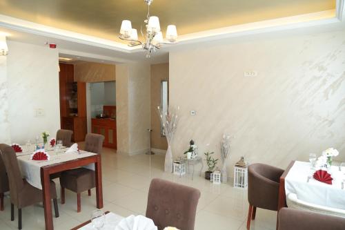 a dining room with two tables and chairs with red bows at Hotel Orion in Ivanec