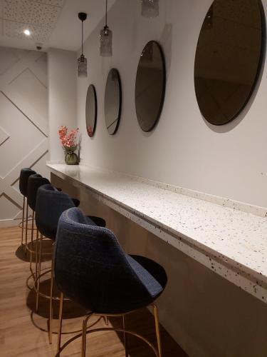 a bar with chairs and mirrors on the wall at Habital Suites in Jaca