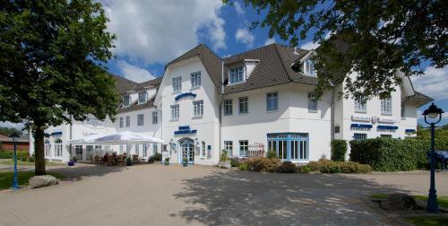 a large white building with a roof at Hotel Wikingerhof in Kropp