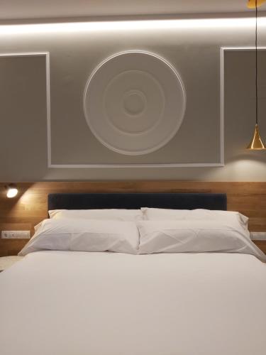 a bedroom with a white bed with a cd on the wall at Habital Suites in Jaca