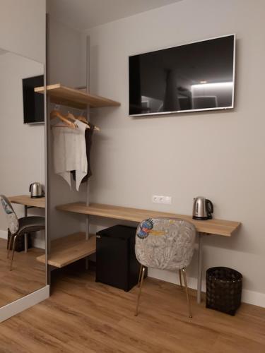 a room with a desk and a chair and a television at Habital Suites in Jaca