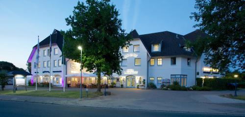 a large white building on the side of a street at Hotel Wikingerhof in Kropp