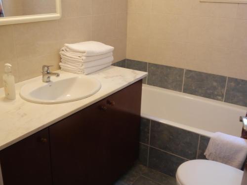 a bathroom with a sink and a toilet and a tub at Byreva Apartments in Paphos