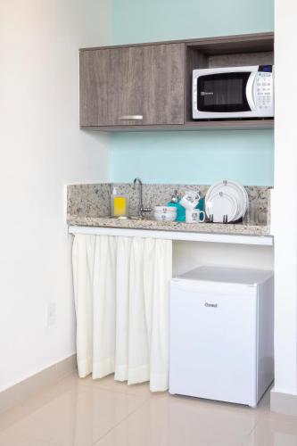a kitchen with a counter with a microwave at K1 RESIDENCE Taquaral in Campinas