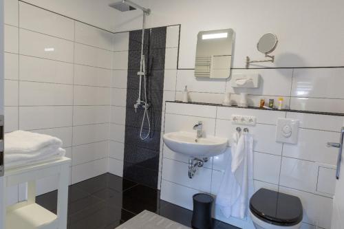 a white bathroom with a sink and a mirror at Clara Hills in Eberswalde