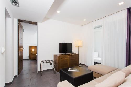 a living room with a couch and a tv at Avala Resort & Villas in Budva