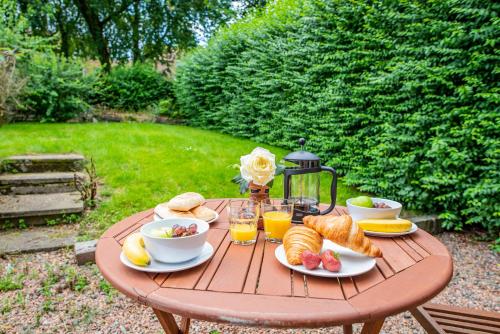 a wooden table with breakfast foods and drinks on it at Stirling Venus Apartment - Scotland Holiday Let in Stirling