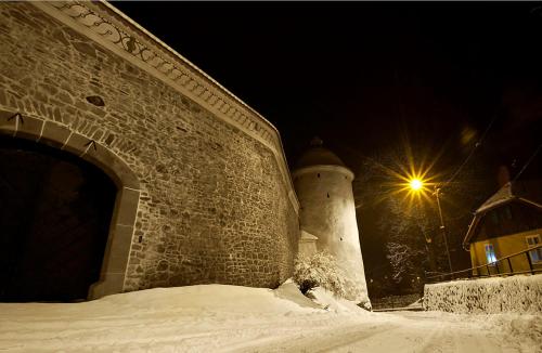 a brick wall with a light next to a building at Pokoje w Moszczenicy U Pasonia in Stary Sącz