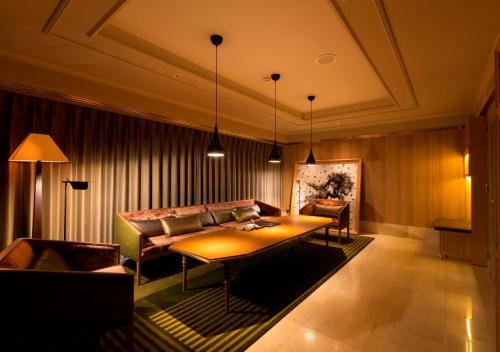 a living room with a table and a couch at Royal Park Hotel Takamatsu in Takamatsu