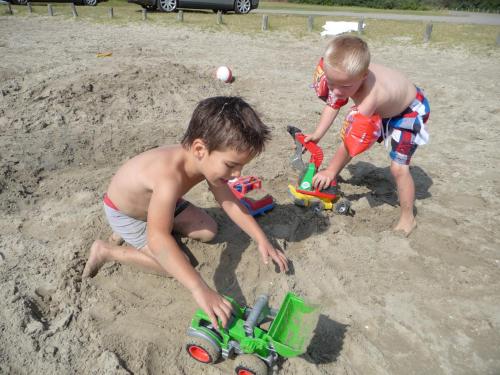 two boys playing with toys in the sand at Klepperstee Esdoorn 3 in Ouddorp