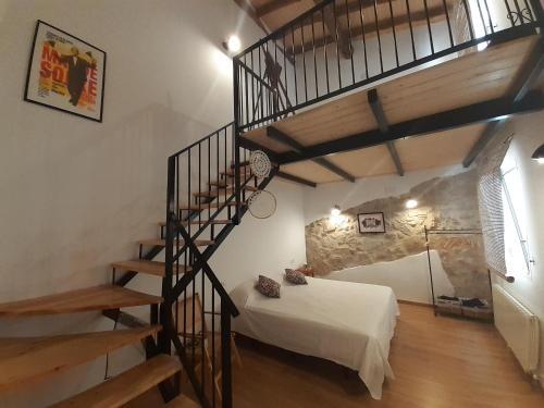 1 dormitorio con escalera y 1 cama en una habitación en Casa La Foradada, en Corbera