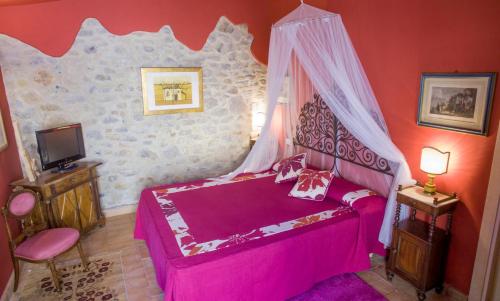 a bedroom with a pink bed with a canopy at Antico Podere Vitiano - Luxury country house in Castel Viscardo