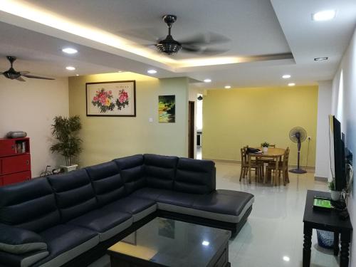 a living room with a black couch and a table at EJ Guesthouse in Cukai