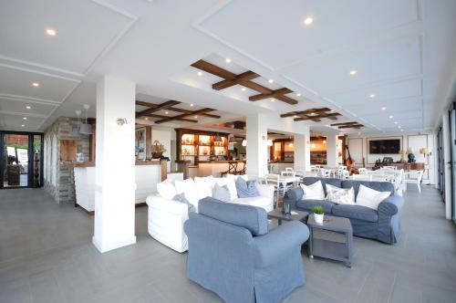- un hall avec des canapés blancs, des tables et des chaises dans l'établissement Vila Bisera, à Ohrid