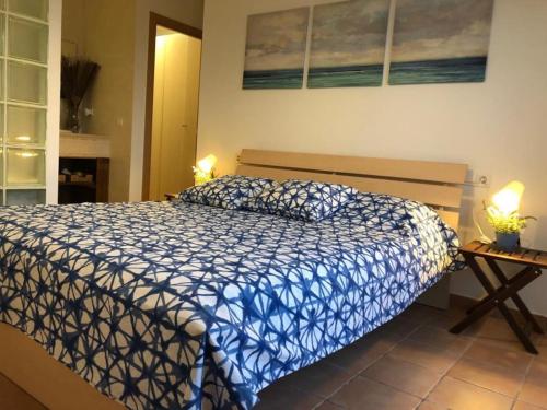 1 dormitorio con 1 cama con edredón azul y blanco en Casa Bella Vista en montaña con vistas al mar y piscina privada, en Cunit