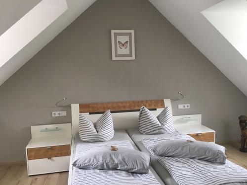 two beds in a attic room with white walls at Appartement & Pension Schmidt Kosma in Altenburg