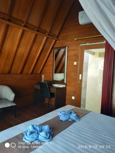 a bedroom with a bed with blue towels on it at Talent Sunset Villa in Gili Islands