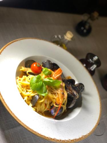 a white bowl of food with mushrooms and vegetables at Casa Mignon in Oradea