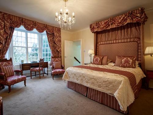 duża sypialnia z dużym łóżkiem i żyrandolem w obiekcie Hempstead House Hotel & Restaurant w mieście Sittingbourne