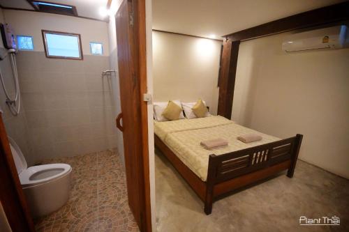 a small bathroom with a bed and a toilet at พืชไทยเชียงคาน(Plantthai) in Chiang Khan