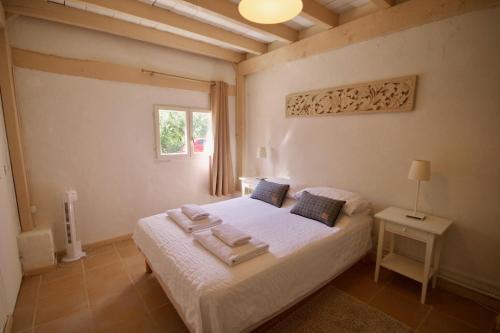 Schlafzimmer mit einem Bett mit weißer Bettwäsche und einem Fenster in der Unterkunft Le Cuvier in Sarlat-la-Canéda