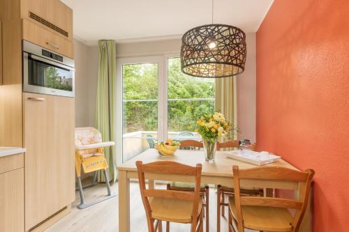a kitchen with a table with chairs and a window at Center Parcs Sauerland Winterberg-Medebach in Medebach