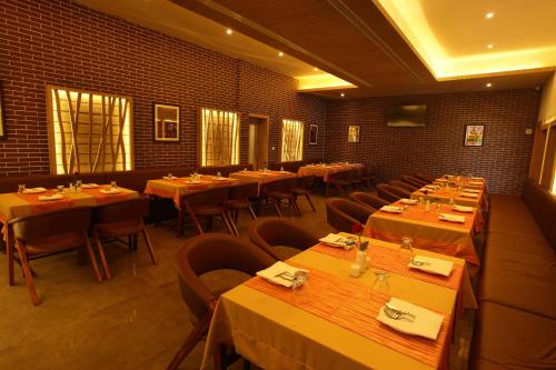a dining room with tables and chairs in a restaurant at Victory Inn Park Residency in Kunnamkulam