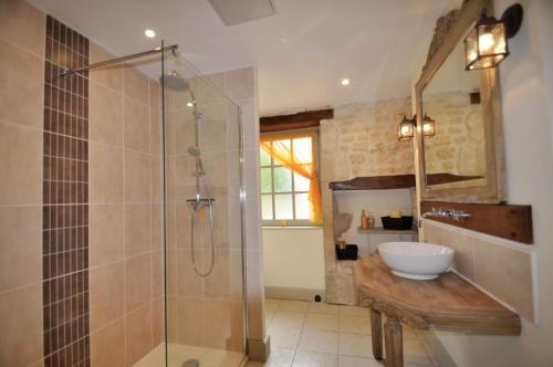 a bathroom with a glass shower and a sink at Chez Fins Bois in Néré