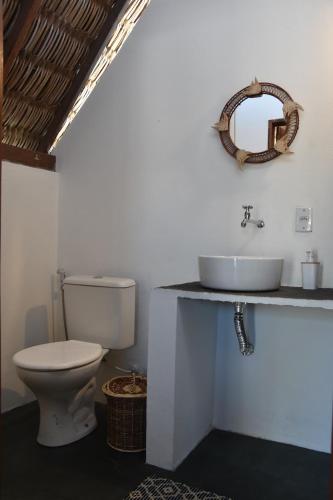 a bathroom with a white toilet and a sink at Pousada Velho Bateau in Atins