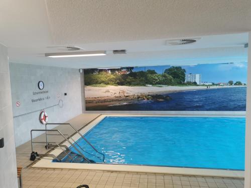 a large wall mural of a swimming pool in a room at Pelzerhaken Prinz Hamlet 26 in Neustadt in Holstein