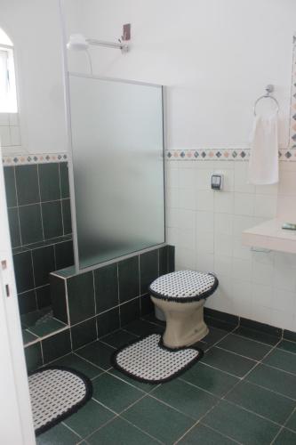 La salle de bains est pourvue d'une douche et de toilettes. dans l'établissement Pousada Calu, à Cunha