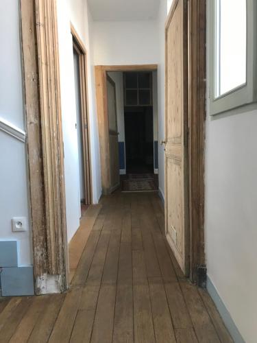 an empty hallway with wood floors and a door at La Menuiserie in Épernay