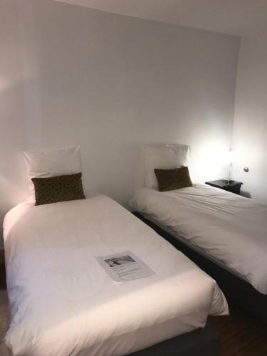 two beds sitting next to each other in a room at La Menuiserie in Épernay
