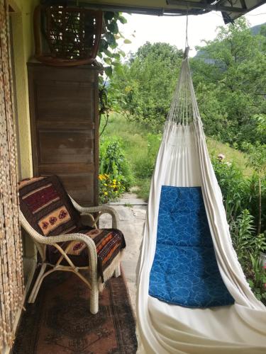a hammock on a porch with a chair and a window at Arve in Bitsch