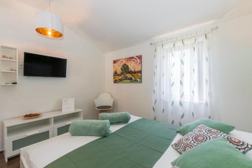 a bedroom with two beds and a flat screen tv at B&B Carmela in Umag