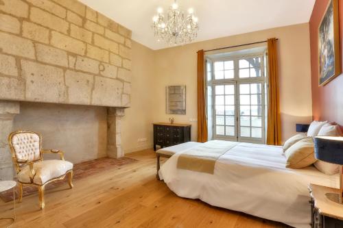 a bedroom with a large bed and a fireplace at La Maison des Consuls in Périgueux