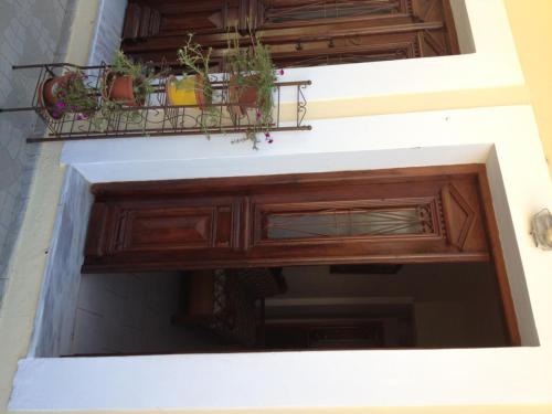 a balcony with potted plants on a building at Nikos and Eva Studios in Symi