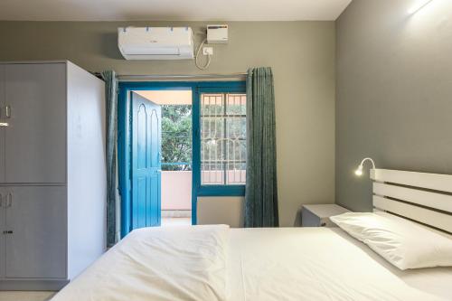 a bedroom with a bed and a blue door at Woke HSR layout in Bangalore