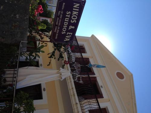 a building with a sign on the side of it at Nikos and Eva Studios in Symi