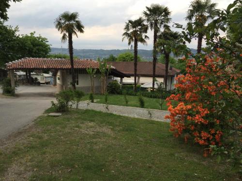 a house with palm trees and a yard at Campeggio Haway in Viverone