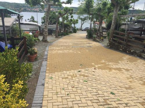 a brick walk way with trees and a fence at Campeggio Haway in Viverone