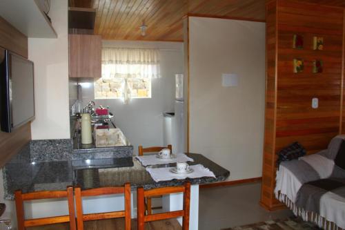 a kitchen with a counter with a sink and a refrigerator at Apartamento Serrano in São Joaquim