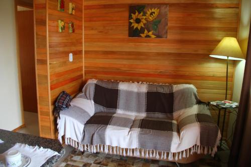 sypialnia z drewnianymi ścianami i łóżkiem z kocem w obiekcie Apartamento Serrano w mieście São Joaquim