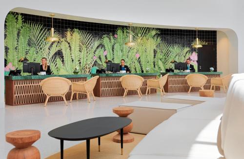 a lobby with people sitting at a bar at H10 Atlantic Sunset Horizons Collection in Adeje