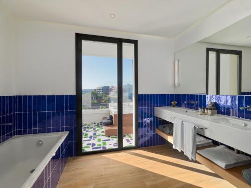a bathroom with a tub and a large window at H10 Atlantic Sunset Horizons Collection in Adeje