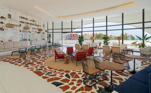 a lobby with tables and chairs and windows at H10 Atlantic Sunset Horizons Collection in Adeje